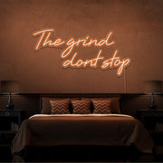 orange the grind dont stop neon sign hanging on bedroom wall