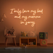 orange I only love my bed and my momma I'm sorry neon sign hanging on kids wall