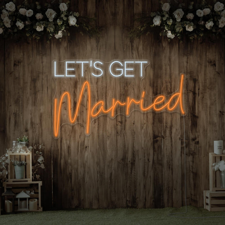 orange lets get married neon sign hanging on timber wall