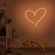 orange love heart neon sign hanging on kids bedroom wall