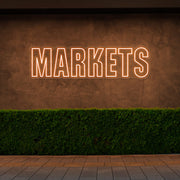 orange markets neon sign hanging on outside wall