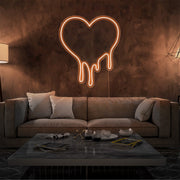orange melting heart neon sign hanging on living room wall