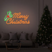 orange merry chirstmas mistletoe neon sign hanging above couch next to christmas tree