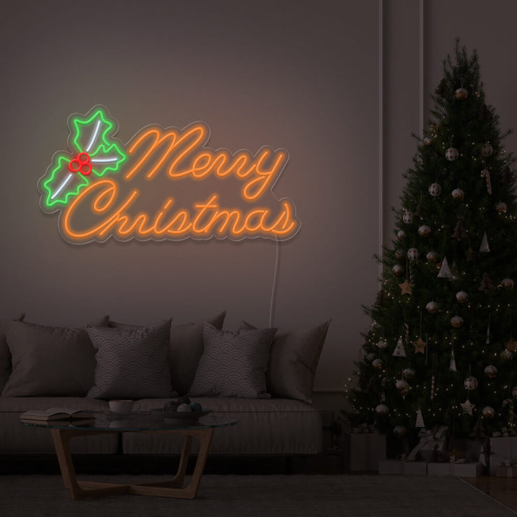 orange merry chirstmas mistletoe neon sign hanging above couch next to christmas tree
