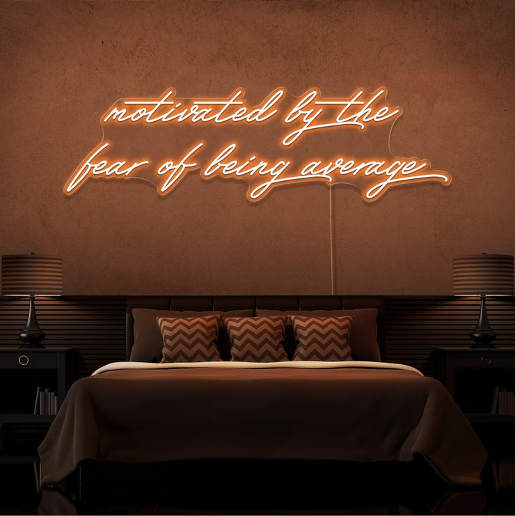 orange motivated by the fear of being average neon sign hanging on bedroom wall