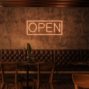 orange open neon sign hanging on cafe wall
