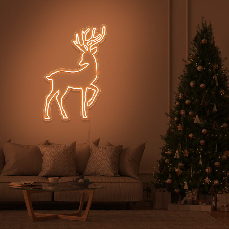 orange reindeer neon sign hanging on living room wall next to christmas tree