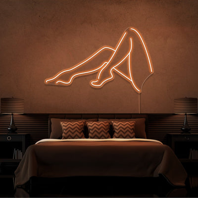 orange sexy legs neon sign hanging on bedroom wall