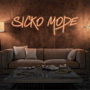 orange sicko mode neon sign hanging on living room wall