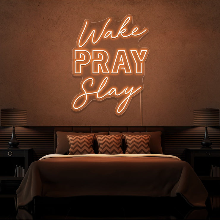 orange wake pray slay neon sign hanging on bedroom wall