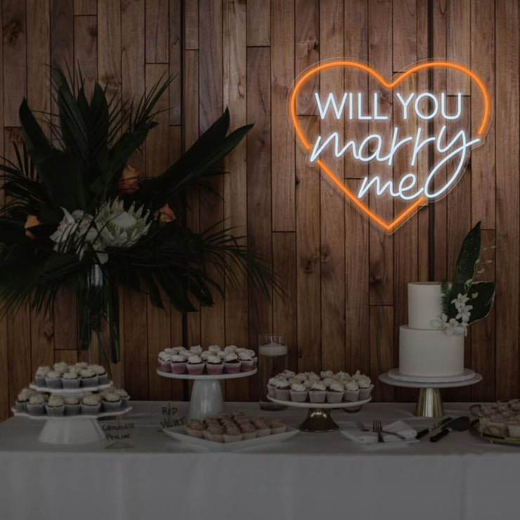 orange will you marry me heart neon sign hanging on timber wall above dessert table