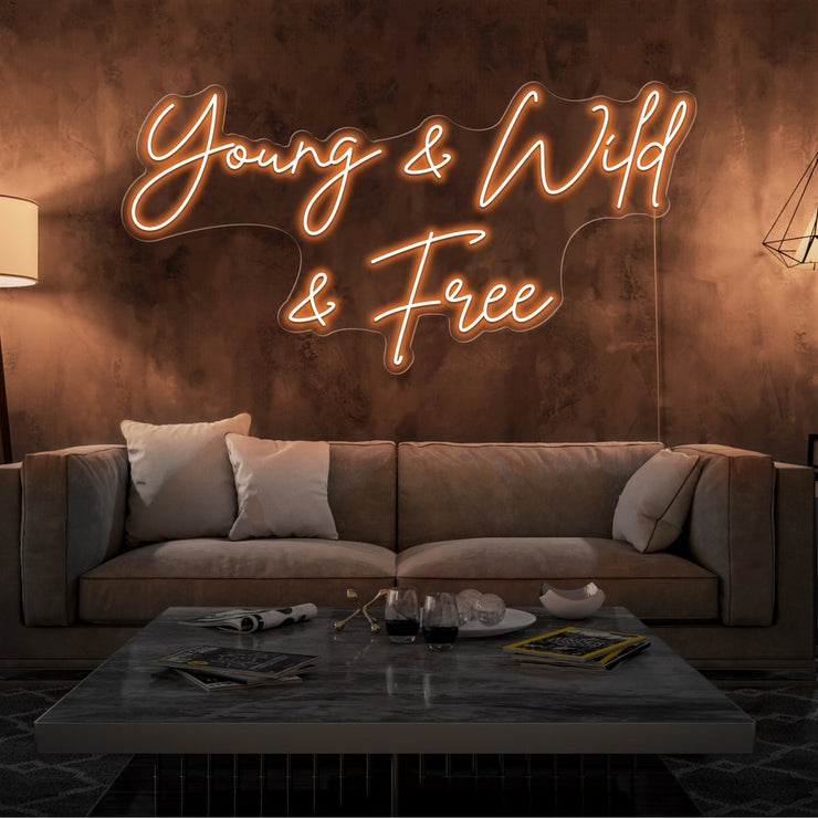 orange young and wild and free neon sign hanging  on living room wall