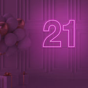 hot pink  21 neon sign hanging on wall with balloons