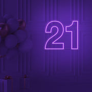 purple  21 neon sign hanging on wall with balloons