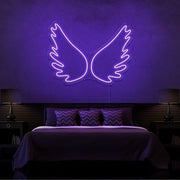 purple angel wings neon sign hanging on bedroom wall
