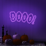 purple boo neon sign with halloween pumpkins on floor
