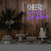 purple cheers to love neon sign hanging above dessert table