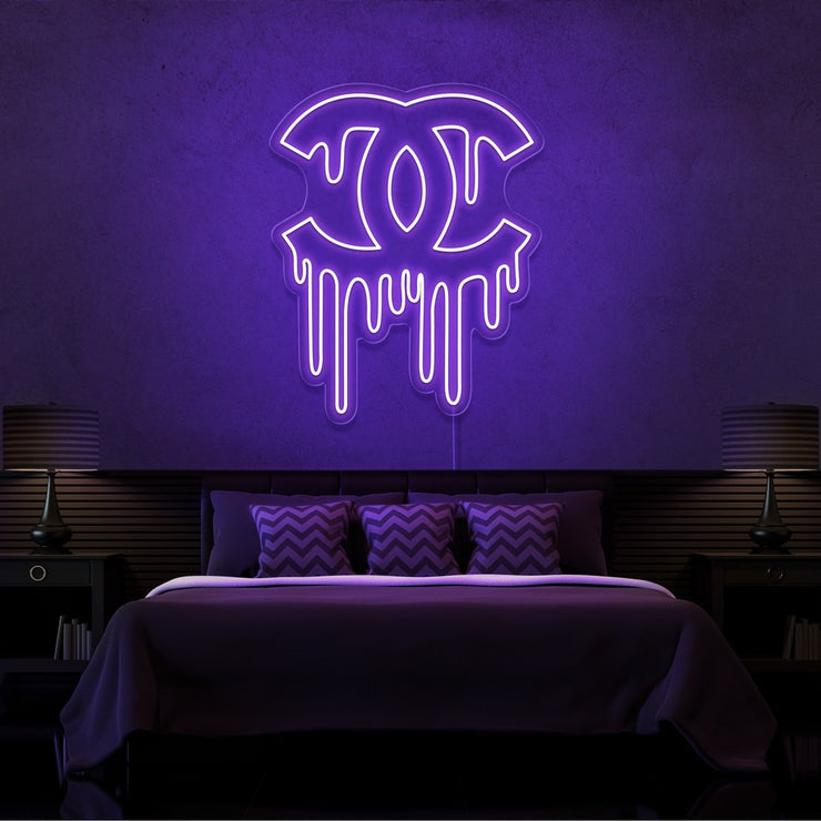 purple dripping chanel neon sign hanging on bedroom wall