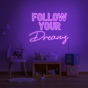 purple follow your dreams neon sign hanging on kids bedroom wall