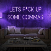 purple lets fuck up commas neon sign hanging on living room wall