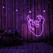purple ghost neon sign hanging on timber wall