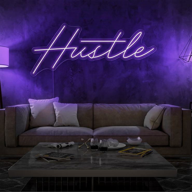 purple hustle neon sign hanging on living room wall