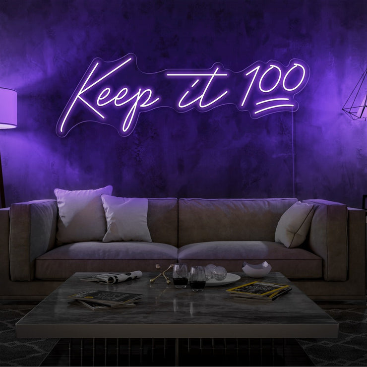 purple keep it 100 neon sign hanging on living room wall