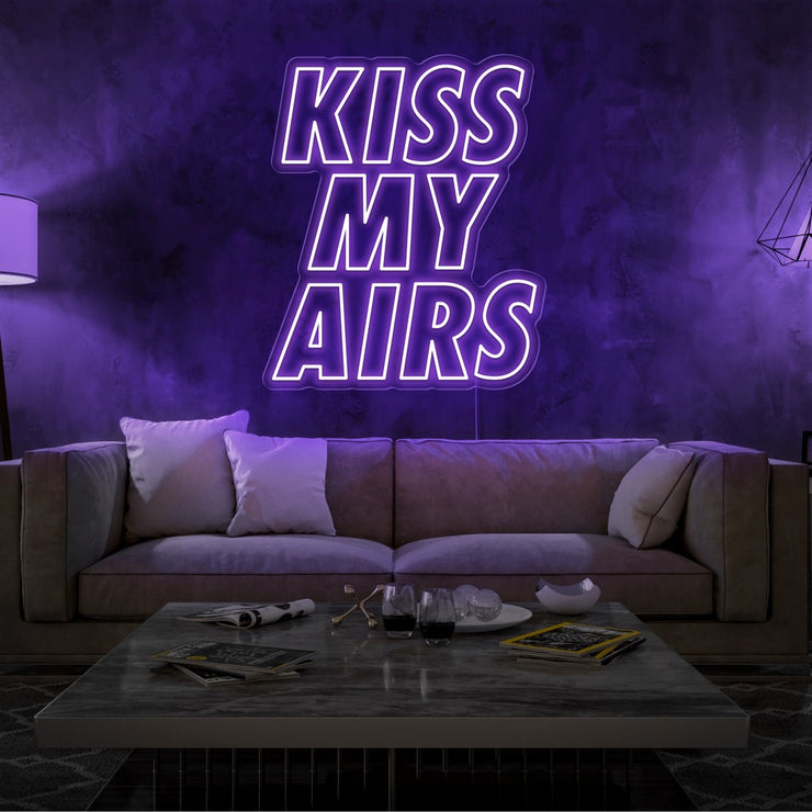 purple kiss my airs neon sign hanging on living room wall