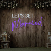 purple lets get married neon sign hanging on timber wall