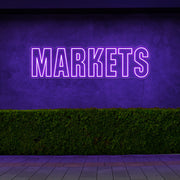 purple markets neon sign hanging on outside wall