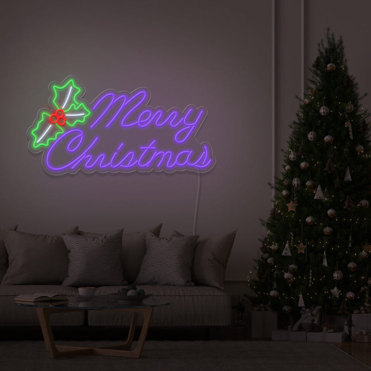 purple merry chirstmas mistletoe neon sign hanging above couch next to christmas tree