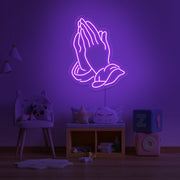 purple praying hands neon sign hanging on kids bedroom wall