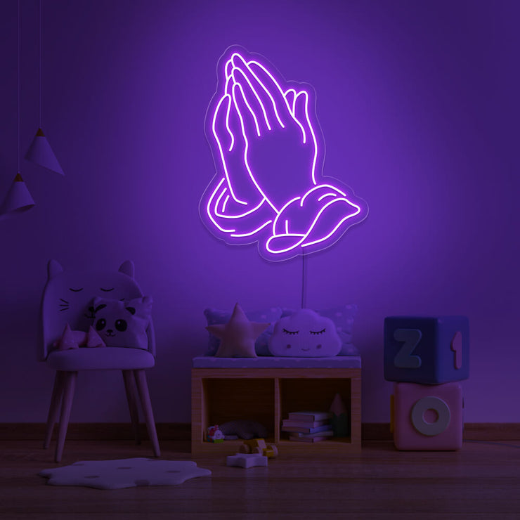 purple praying hands neon sign hanging on kids bedroom wall