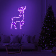 purple reindeer neon sign hanging on living room wall next to christmas tree
