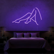 purple sexy legs neon sign hanging on bedroom wall