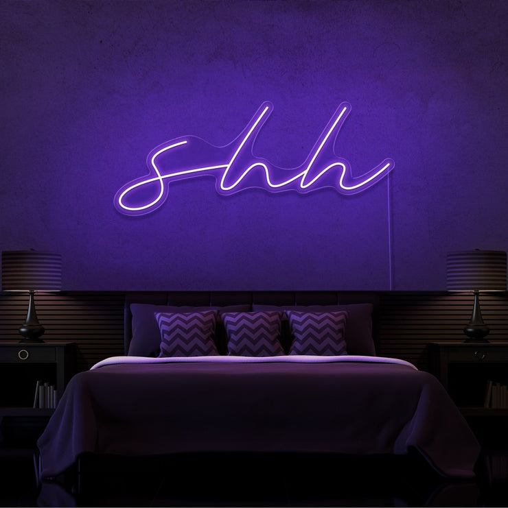 purple shh neon sign hanging on bedroom wall
