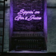 purple sippin on gin and juice neon sign hanging on bar wall