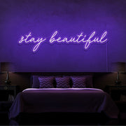 purple stay beautiful neon sign hanging on bedroom wall