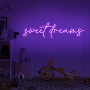 purple sweet dreams neon sign hanging on kids bedroom wall