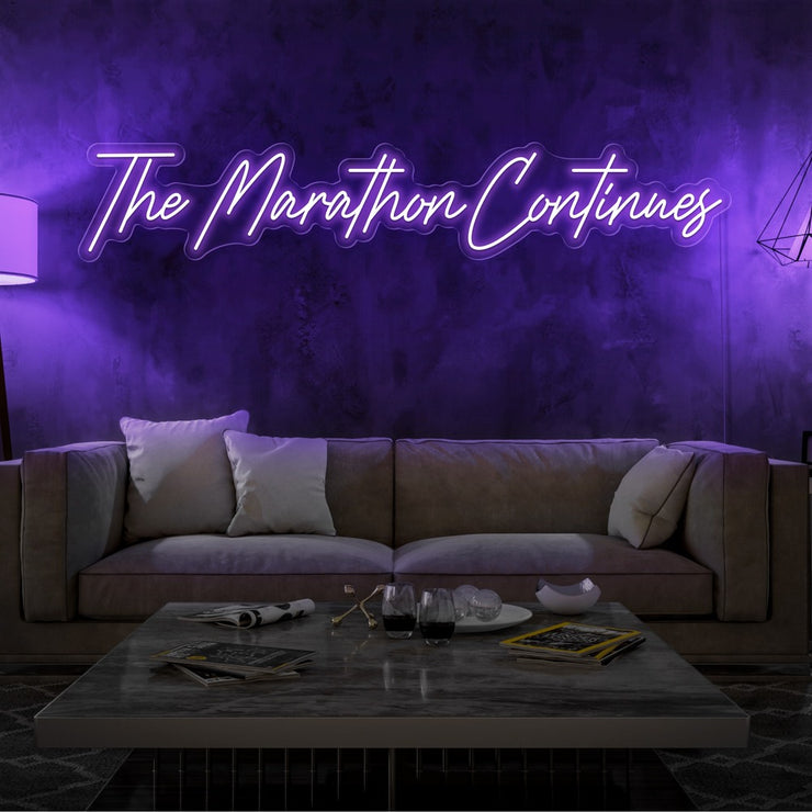 purple the marathon continues neon sign hanging on living room wall