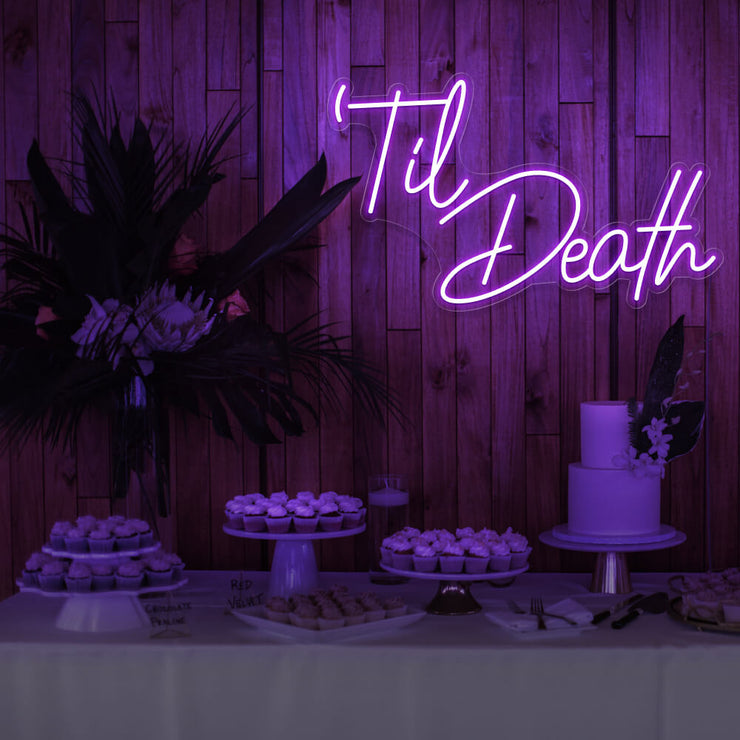 purple til death neon sign hanging on timber wall above dessert table