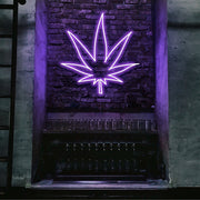 purple weed leaf neon sign hanging on bar wall