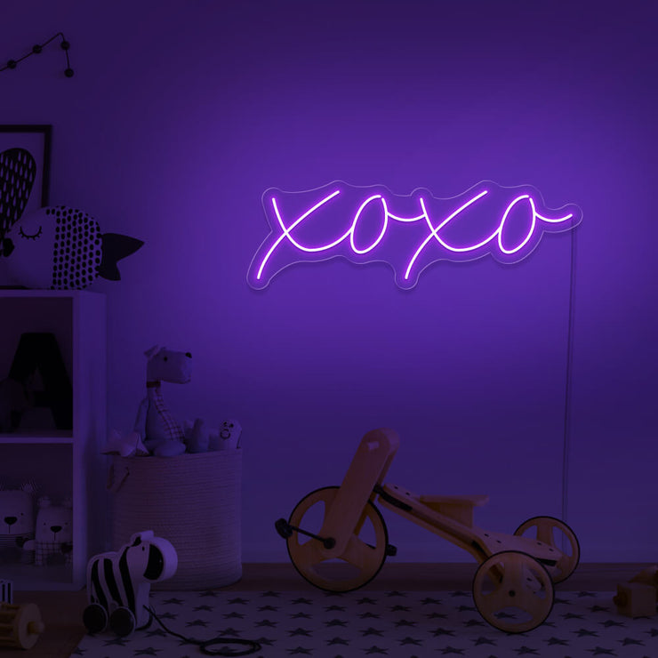 purple xoxo neon sign hanging on kids bedroom wall