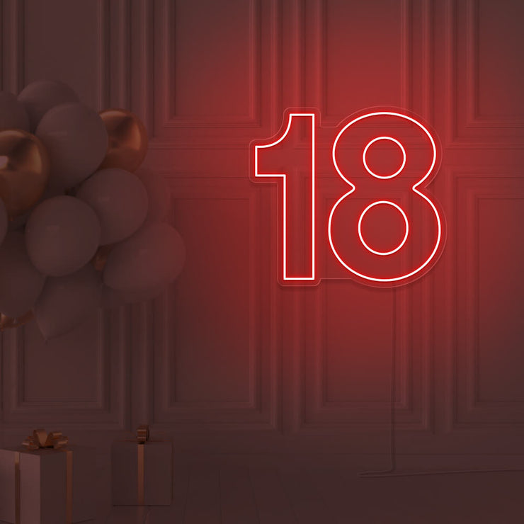 red 18 neon sign hanging on wall with balloons