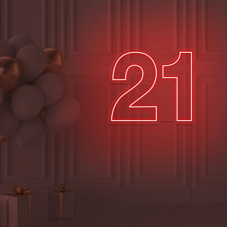 red  21 neon sign hanging on wall with balloons