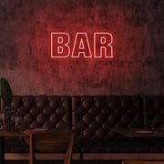 red bar neon sign hanging on bar wall