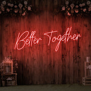 red better together neon sign hanging on timber wall