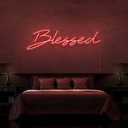 red blessed neon sign hanging on bedroom wall