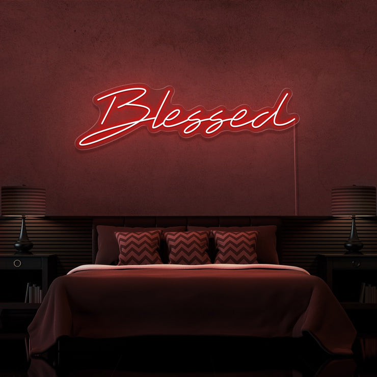red blessed neon sign hanging on bedroom wall