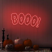 red boo neon sign with halloween pumpkins on floor